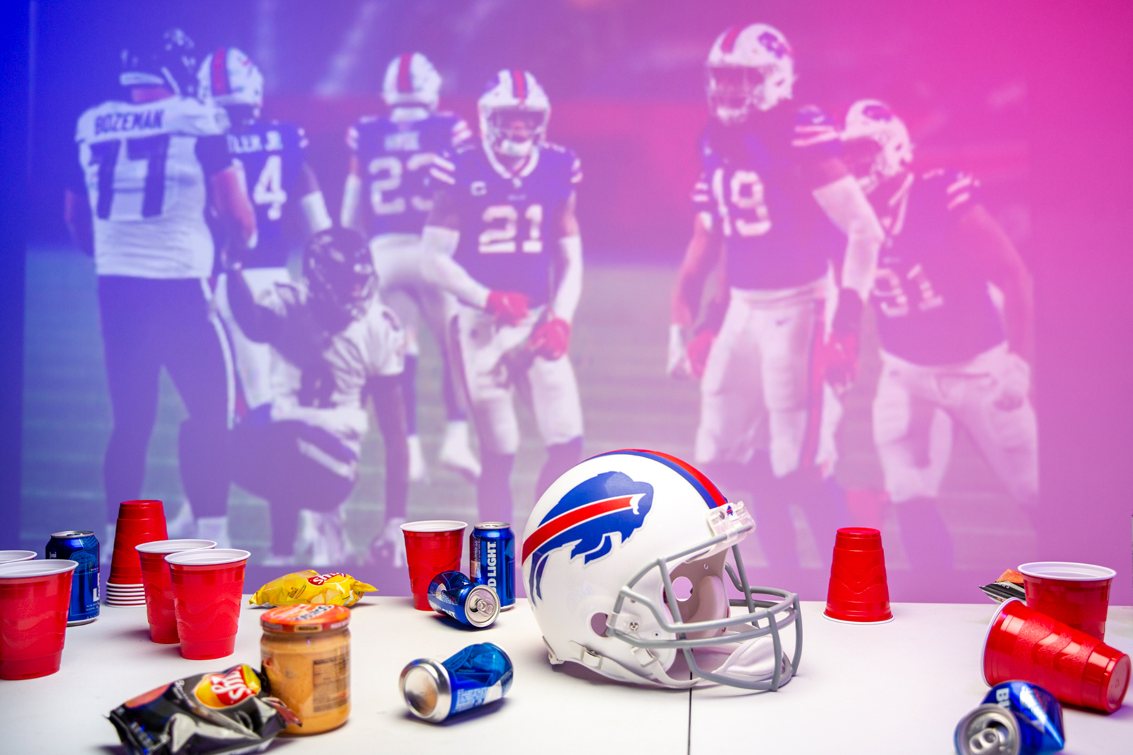 A Buffalo Bills helmet on a table in front of images of football players