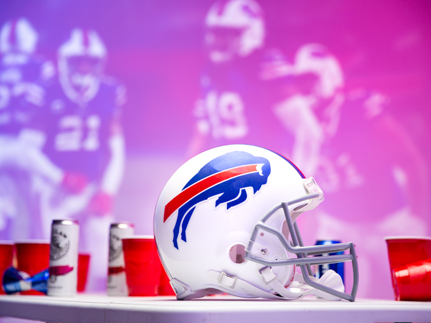 A Buffalo Bills helmet on a table in front of images of football players