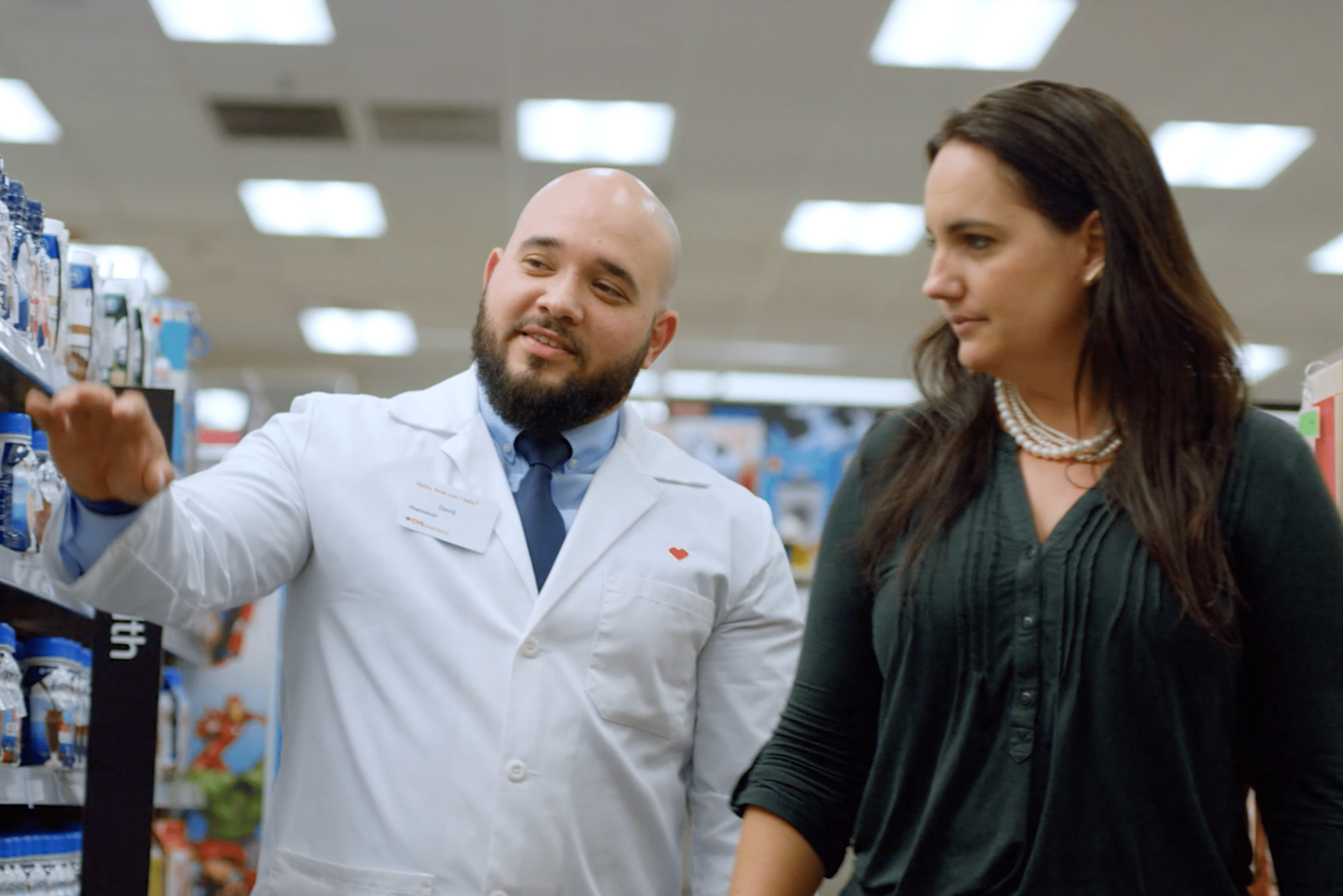 A pharmacist shows a guest items in the aisle of a CVS Pharmacy location.