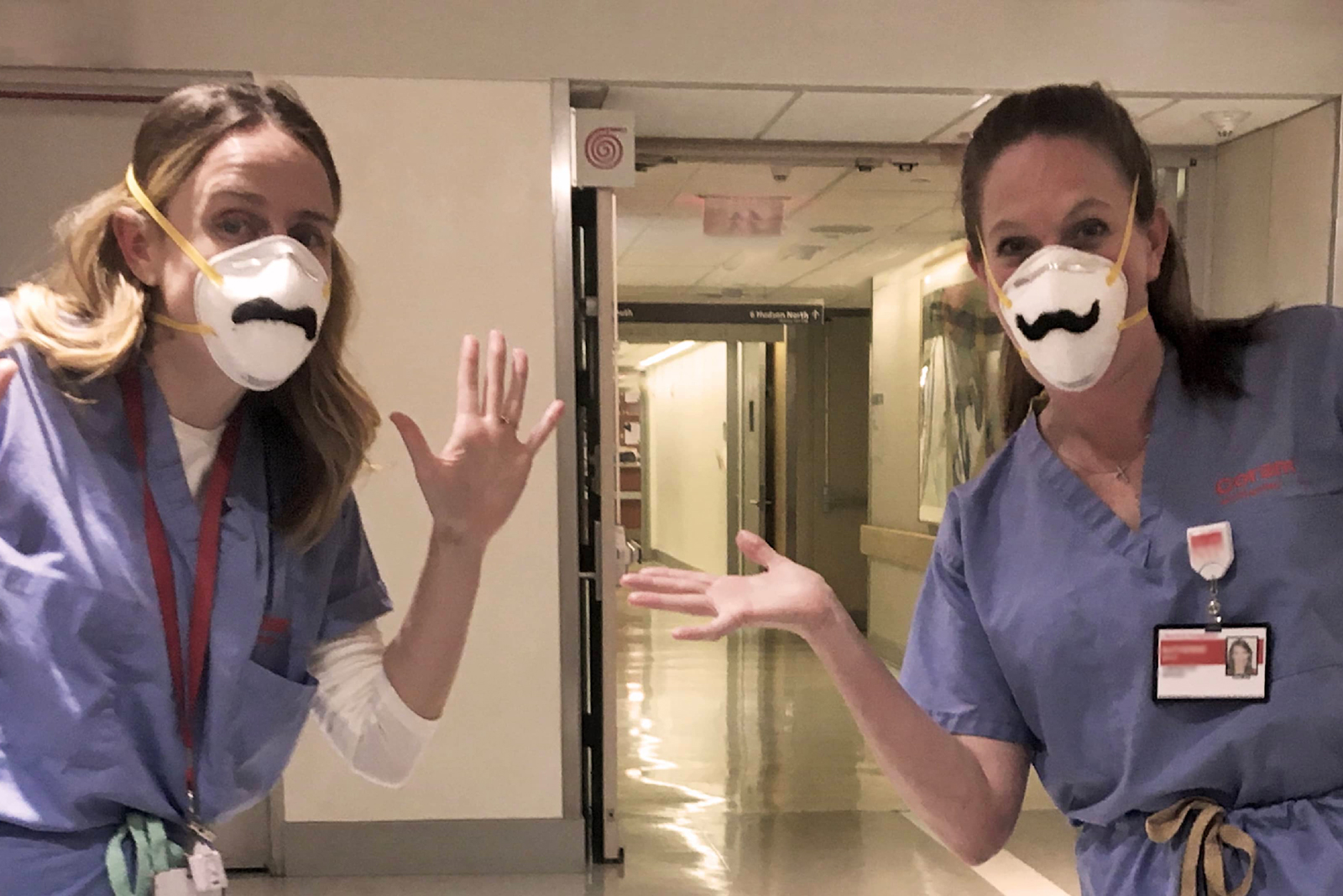 Two nurses show off "Whimsical Care Kits" that feature silly mustaches to add to a face mask.