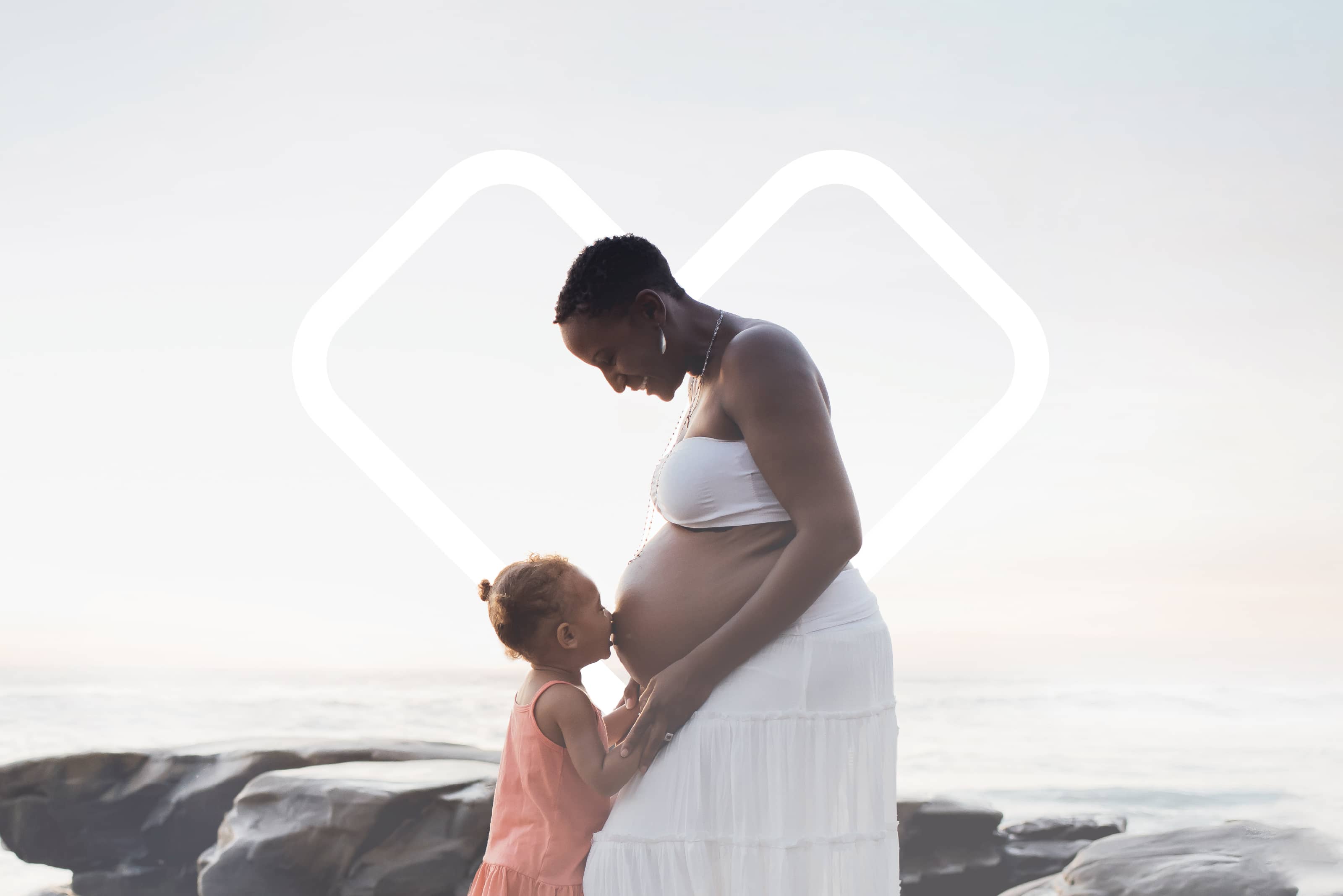A pregnant mother and child embrace with the CVS Health Heart logo in the background.