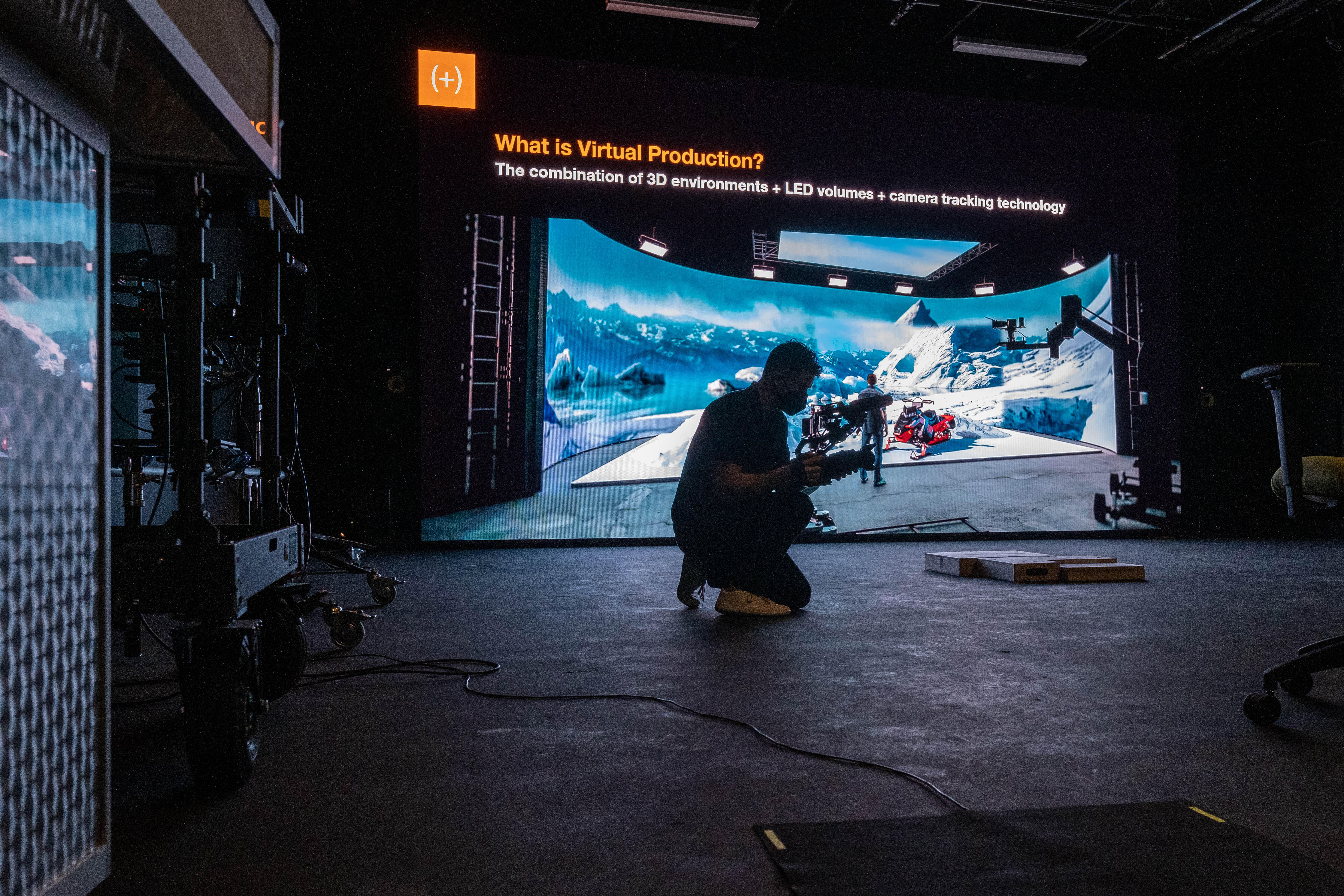 A man crouches to take video of a new video production technology