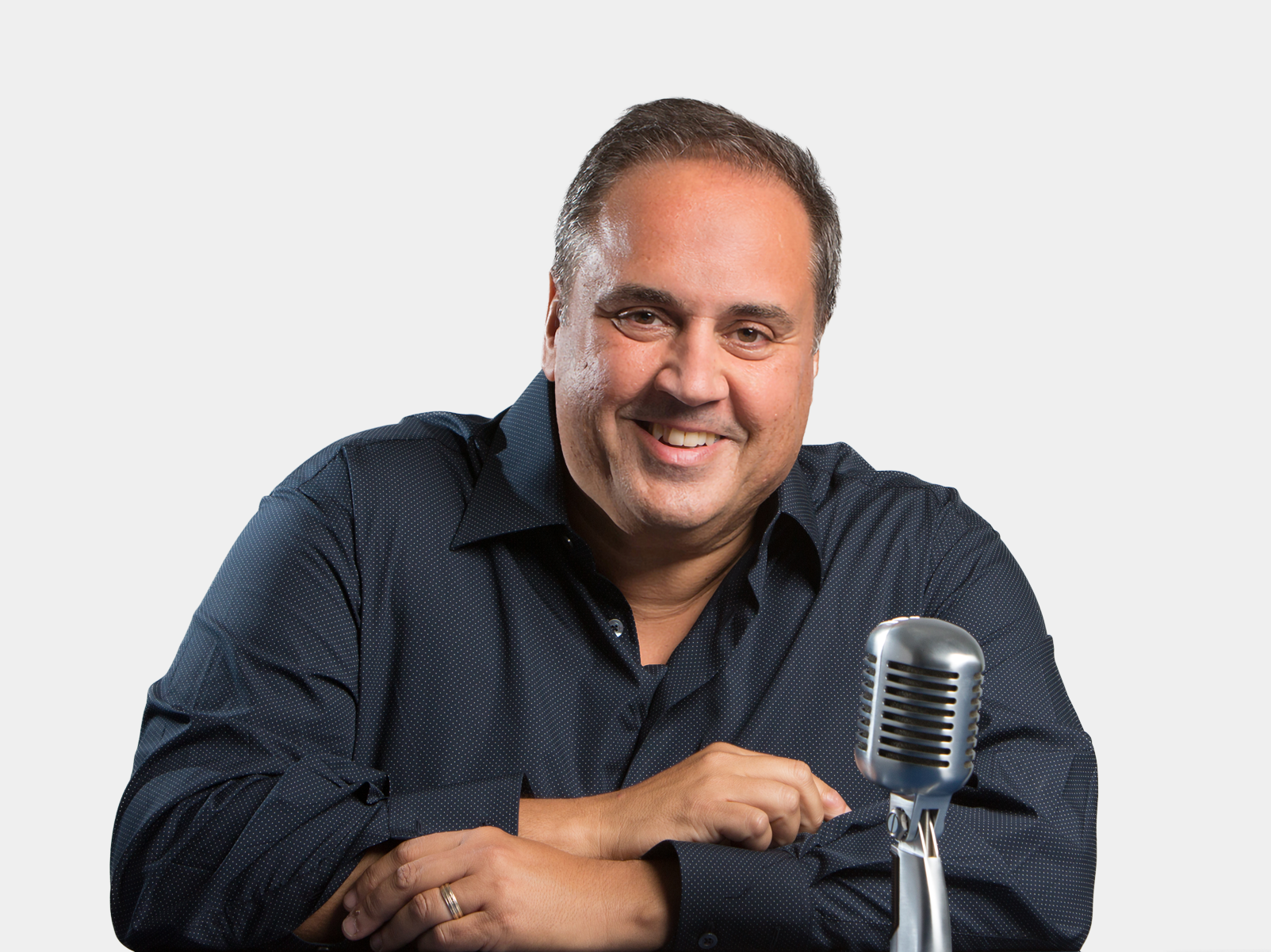 Steve Rosa smiling with a microphone against a white background